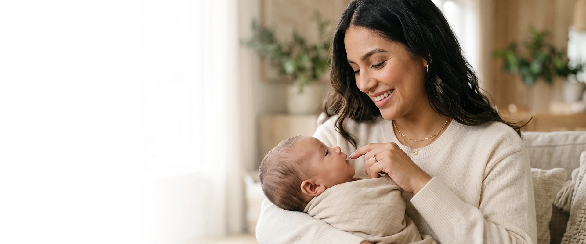Imagen referencial de una madre sonriendo mientras sostiene a su bebé